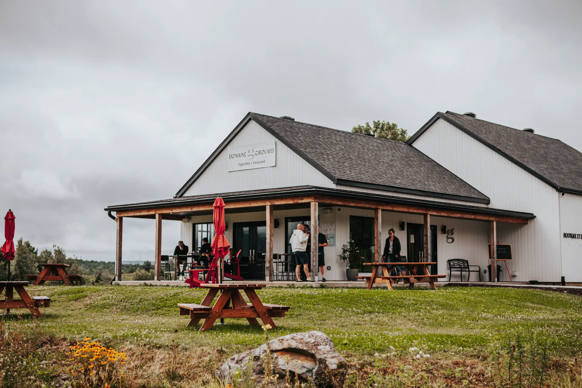 vignoble domaine girouard route des vins brome missisquoi Vignoble Domaine Girouard sur la Route des vins Brome-Missisquoi. Visiteurs sur la terrasse et tables de pique-nique sur la pelouse fleurie.