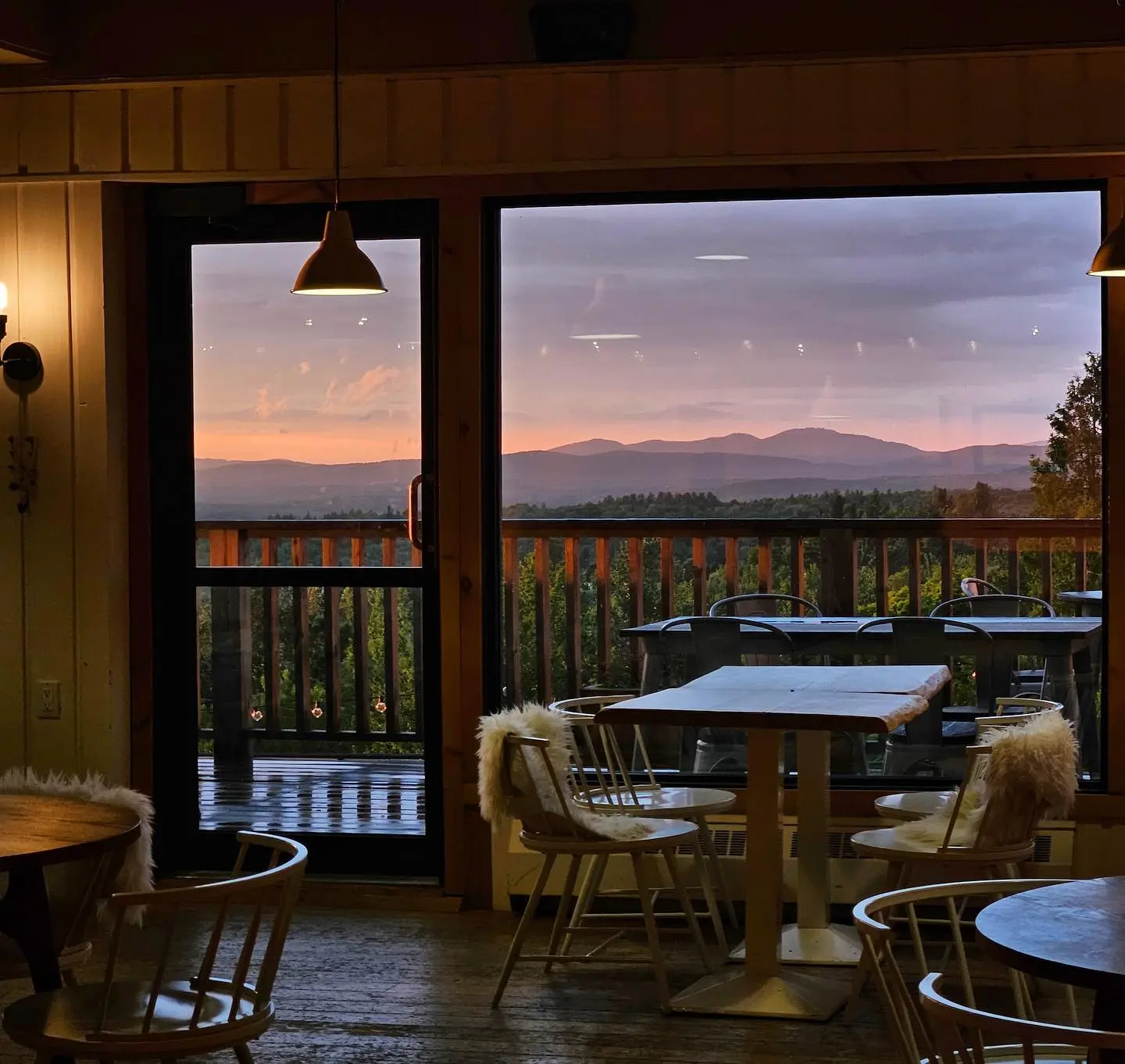 vue panoramique route des vins brome missisquoi Intérieur chaleureux de l'Hôtel Horizon, avec vue sur un coucher de soleil montagneux des Cantons-de-l'Est, le long de la Route des vins de Brome-Missisquoi.